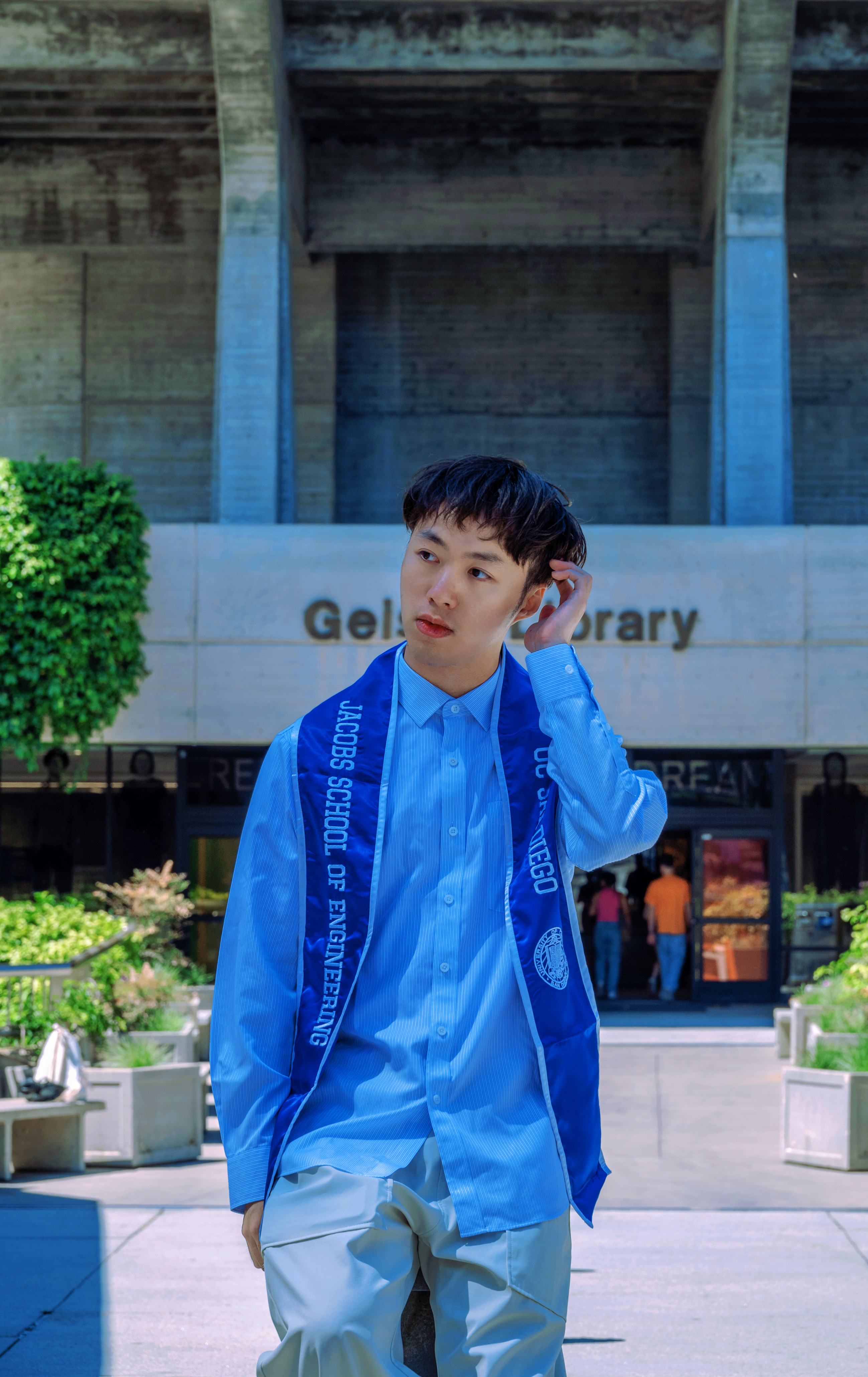 Yizhan wearing graduation dress in front of Geisel Library